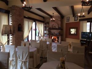 restauracja z białymi stołami i krzesłami oraz kominkiem w obiekcie Green Hotel - Maravel Botanical Garden w mieście Spílion +37 zdjęć