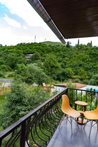 a balcony with three chairs and a view of a hill at Spitak tun in Ijevan