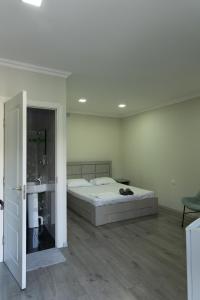 a white bedroom with a bed and a sink at Spitak tun in Ijevan