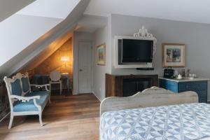 a bedroom with a bed and a flat screen tv at Auberge Place d'Armes in Quebec City