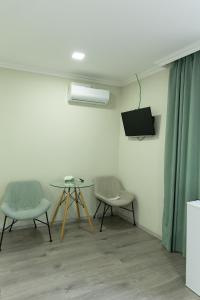 a room with two chairs and a table and a tv at Spitak tun in Ijevan +3 photos