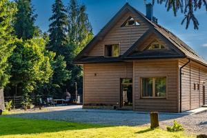 a wooden house with a gambrel roof at Domek nad Potokiem 2 in Nowy Targ