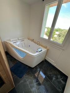 a white bath tub in a room with a window at Ó maestro home in Avignon +11 photos