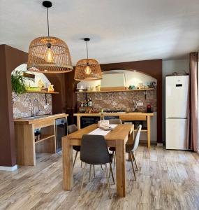 a kitchen with a table and chairs and a refrigerator at Sa tanca 'e Pedduzza in Orosei +22 photos