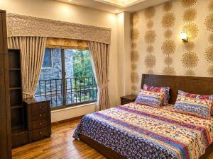 a bedroom with a bed and a large window at Luxury Noor Villa in Khaira Gali