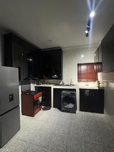 a kitchen with a stove and a dishwasher at Jasabi Apartments in Port Harcourt