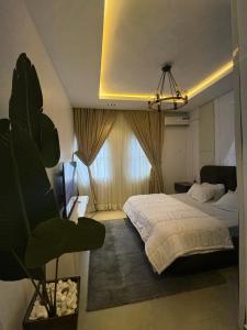 a bedroom with a bed and a large window at Jasabi Apartments in Port Harcourt