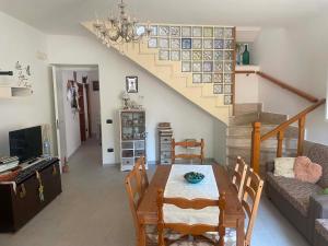 a living room with a dining table and a staircase at Surripe Casa Vacanze in San Lorenzello