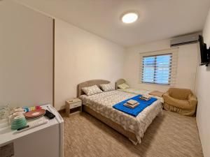 a small bedroom with a bed and a chair at Sobe Baosici Marina in Herceg-Novi