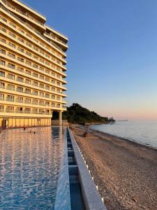 a large building on the beach next to the ocean at Go Bamboo Beach Apartments in Ts'ikhisdziri