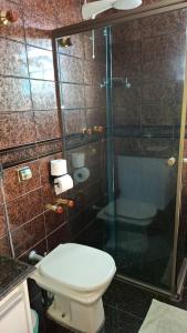 a bathroom with a toilet and a glass shower at SUÍTE Solar do Carmo in Mariana