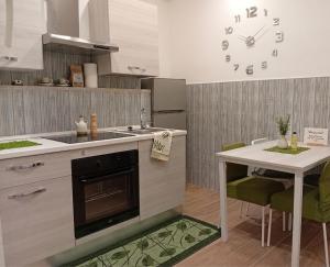 a kitchen with a table and a clock on the wall at Villa del Mare Virgo Home in Nettuno