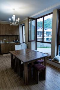 a kitchen with a wooden table and a large window at Spitak tun in Ijevan