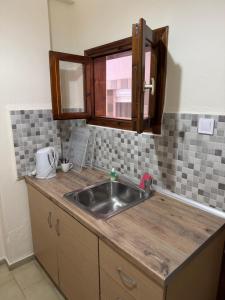a kitchen counter with a sink and a window at PERDIKI STUDIOS in Kokkino Nero +17 photos