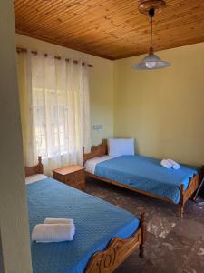 a bedroom with two beds and a window at PERDIKI STUDIOS in Kokkino Nero