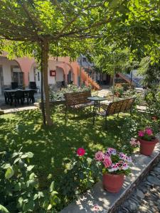 a park with a table and benches and flowers at PERDIKI STUDIOS in Kokkino Nero