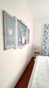 a room with a bed and a window with pictures at Casa do Portão Azul - Tamboril in Atouguia da Baleia