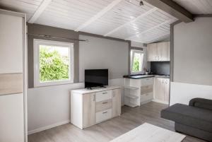 a living room with a television and a kitchen at Domki Bliźniak in Ustka