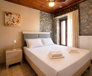 a bedroom with a bed with two towels on it at Stone house Amfikleia in Amfikleia