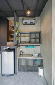 a kitchen with a sink and a refrigerator at Atlas Bangkok Hotel in Bangkok