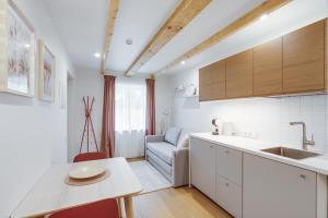 eine Küche mit weißen Schränken, einem Tisch und einem Sofa in der Unterkunft Corner House in Nida + 55 Fotos