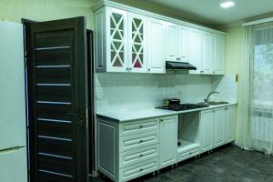a kitchen with white cabinets and a stove top oven at Spitak Tun in Ijevan