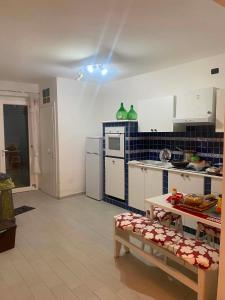 a kitchen with white cabinets and a blue tiled wall at Surripe Casa Vacanze in San Lorenzello