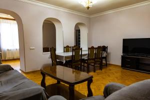 a living room with a table and chairs and a television at Spitak Tun in Ijevan