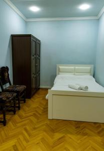 a bedroom with a bed and a chair and a cabinet at Spitak Tun in Ijevan +11 photos
