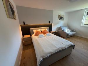 a bedroom with a bed and a chair in it at Biała Stodoła in Płoskie