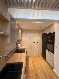 a kitchen with a sink and a black refrigerator at Biała Stodoła in Płoskie