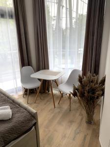 a living room with a table and chairs and a window at Na Rogu in Sandomierz