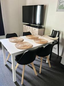 a white table with four chairs around it at Pronssi Villa, Vuokatin ytimessä sisältyy Ilmainen pysäköinti, Sauna, etu terassi ja piha alue, Wi-Fi, SmartTV in Vuokatti
