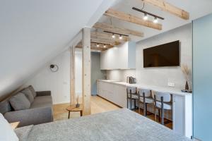 eine Küche und ein Wohnzimmer mit Sofa und Tisch in der Unterkunft Corner House in Nida