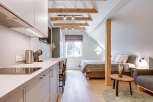 eine Küche und ein Wohnzimmer in einem Loft mit einem Bett in der Unterkunft Corner House in Nida