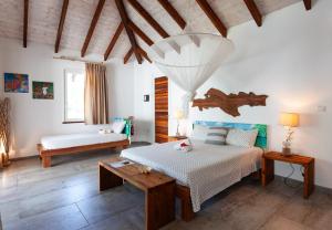 a living room with two beds and a table at Reve Island Lodge in Grand Anse