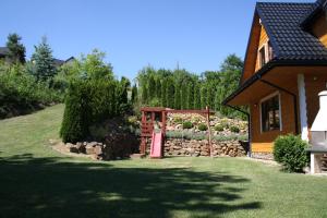 a house with a gate in a yard with a garden at LEŚNY DWOREK 2 in Wołkowyja