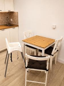 a wooden table and two chairs and a table and a kitchen at Cinque Terre Sweet Home - Centro La Spezia - 5 min stazione - Ideale Cinque Terre - WiFi e AC in La Spezia