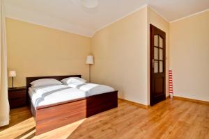a bedroom with a large bed and a wooden floor at HORN Jastarnia in Jastarnia