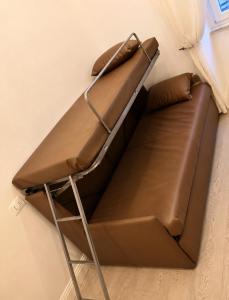 a brown couch in a corner of a room at Cinque Terre Sweet Home - Centro La Spezia - 5 min stazione - Ideale Cinque Terre - WiFi e AC in La Spezia