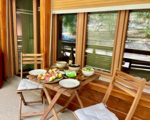 a table with plates and fruit on it in front of a window at Nendaz Alpine Studio - Ski & Swimming Pool in Nendaz