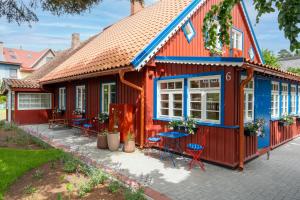 ein rot-blaues Haus mit blauem Dach in der Unterkunft Corner House in Nida