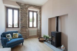 a living room with a blue couch and a stove at Castravalva Villa by Rent All Como in Mezzegra