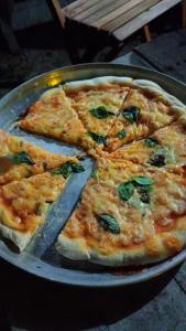 a pizza is cut into slices on a pan at Cabana Jamelão in Camaçari