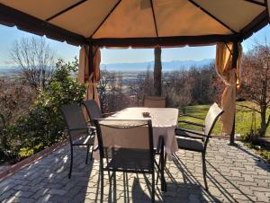 a table and chairs under an umbrella on a patio at L'Albore in Costigliole Saluzzo