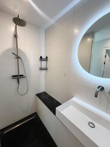 a white bathroom with a sink and a mirror at Studio Margriet in Bergen +28 photos