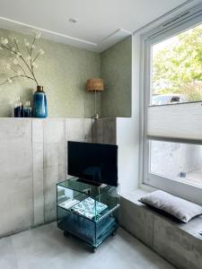 a living room with a glass table and a window at Studio Margriet in Bergen