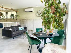a living room with a table and green chairs at Studio Margriet in Bergen