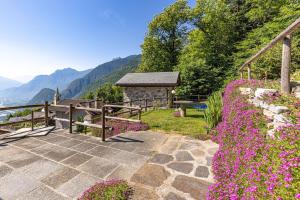 a garden with pink flowers and a bench at Chalet Ca'Stanedi Valchiavenna in Voga