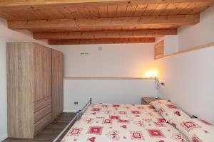a bedroom with a bed and a wooden ceiling at Chalet Ca'Stanedi Valchiavenna in Voga